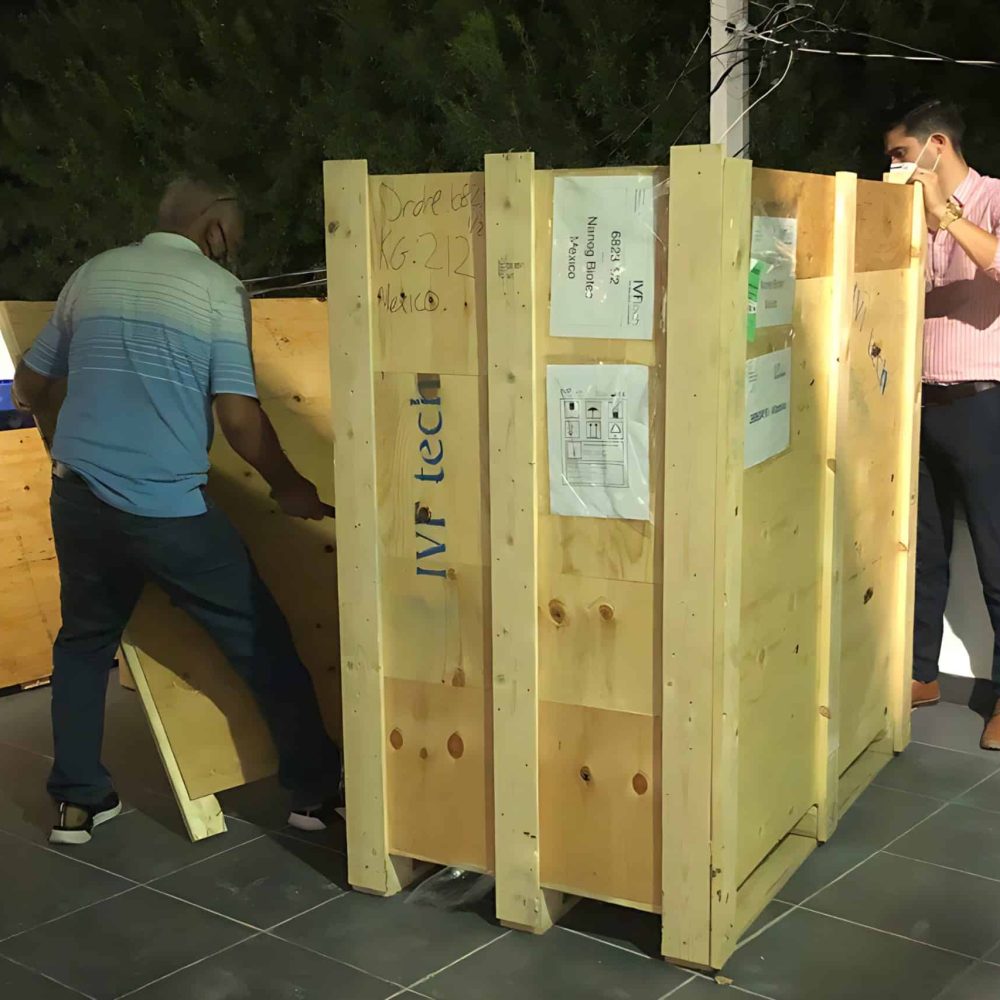 Caja de envío para biotecnología, establecida por Nanog Biotec, en proceso de envío de productos farmacéuticos o biológicos, con personal verificando la preparación.